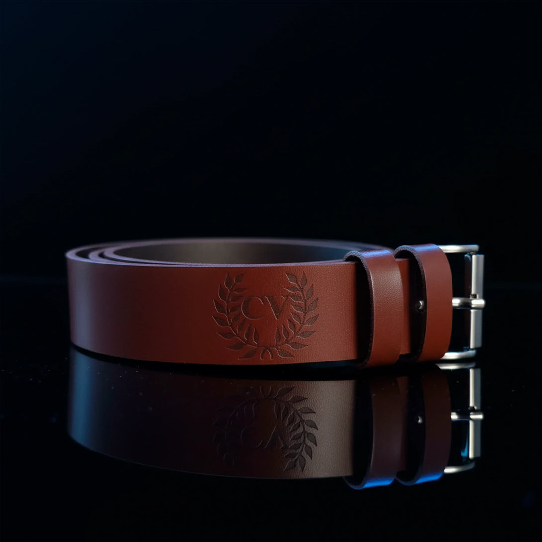 Personalized brown leather belt for men with engraved logo and silver buckle on black background